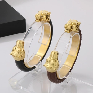 Detail of punk wolf head bracelets with crocodile pattern leather and gold metal finish