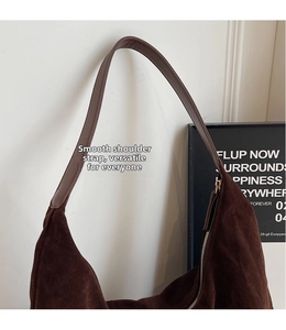 Detail showing smooth brown suede texture and leather strap of the hobo shoulder bag