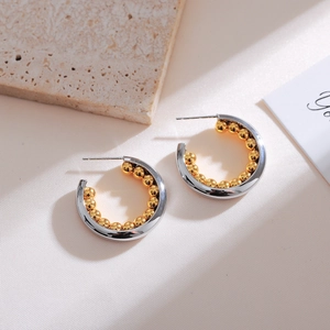 Close-up of minimalist two-tone silver polished hoop earrings with gold bead lining
