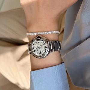 Close-up of a silver tennis bracelet with cubic zirconia paired with a steel wristwatch
