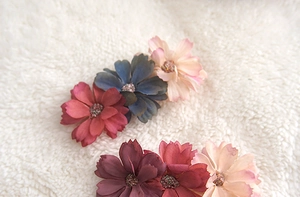 Detail of six colorful handmade fabric floral hair clips with glittered centers