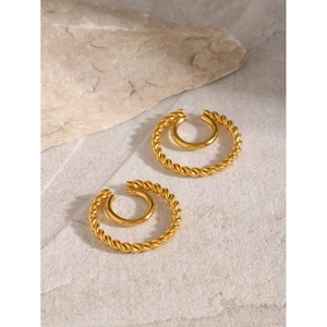 Macro shot of double-layered 18k gold twisted rope and smooth metal cuff earrings