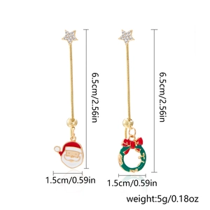 Detail view of asymmetric gold Christmas earrings with Santa and wreath icons
