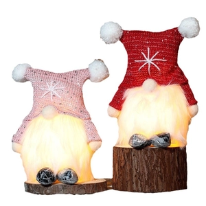 Glowing Christmas gnomes with LED lights on wooden bases in pink and red colors