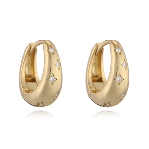 Détail de boucles d'oreilles en U dorées avec incrustation d'étoile en zircon