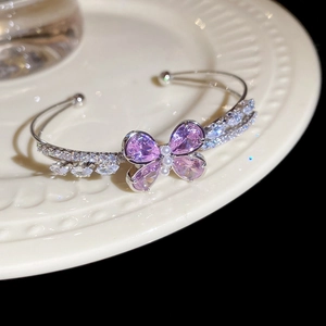 Macro detail of silver butterfly bracelet with lavender zircon and white pearls