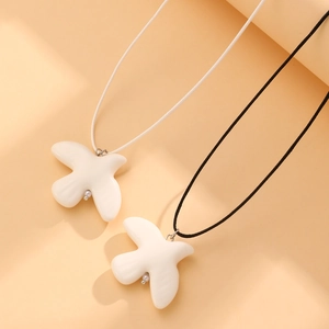 Détail macro du collier pendentif oiseau avec finition céramique lisse et cordon
