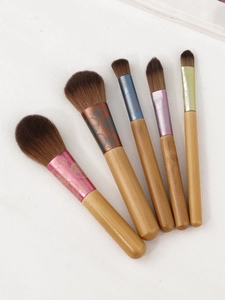 Detailed view of 5-piece mini wood handle makeup brush set with floral engraved ferrules