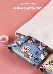 Blue Japanese Maneki Neko notebook cover shown being placed into a canvas bag