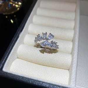 Macro view of silver open ring with multi-shape zircon clusters on wavy velvet padding
