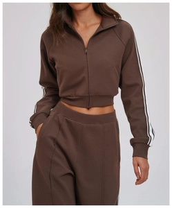 Close-up of brown sporty jacket with high collar and white contrast stripes on sleeves