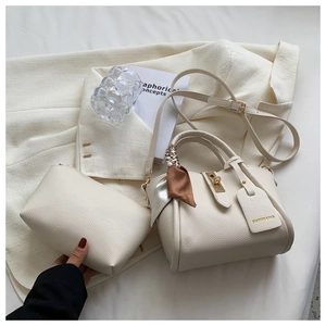 Détail de l'ensemble sac à nœud crème avec cuir texturé et fermoir doré chic