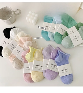 Flat lay of pastel cotton mesh socks with ribbed texture in multiple macaron colors