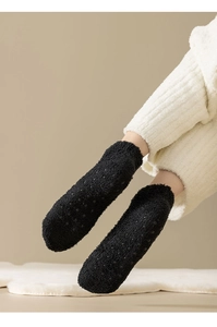 Detail of black thermal coral fleece socks with non-slip silicone grips on the bottom