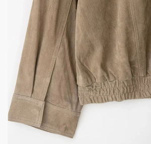 Detail shot of brown suede jacket showing elastic hem and cuff stitching texture