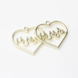 Macro detail of gold-toned alloy heart-shaped pendants with flame hollow design