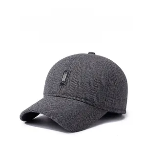 Detail of dark grey herringbone texture and SPORT leather patch on winter baseball cap