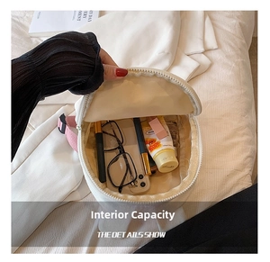 Top view of compact white backpack showing interior capacity for phone and cosmetics