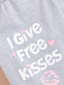 Detail of grey dog shirt with I Give Free Kisses print and pink heart patterns
