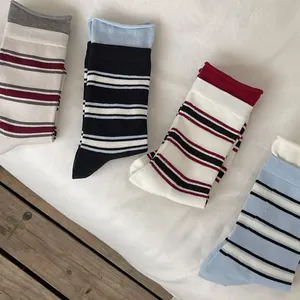 Detail of four pairs of striped mid-calf socks in various colorways with ribbed cuffs