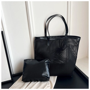 Detail of black mesh tote bag set with matching faux leather inner pouch on a pedestal