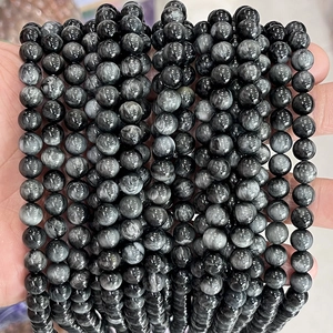 Detailed view of hand-held natural eagle eye stone beads with silky chatoyant luster