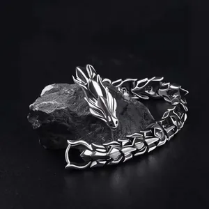 Retro dragon head bracelet in silver stainless steel on a black rock display