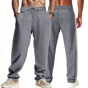 Close-up of grey corduroy trousers with white side stripes and adjustable drawstring waist