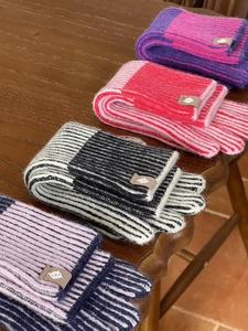 Textura detallada de bufandas de punto a rayas con etiqueta de marca de cuero de calidad