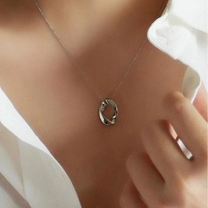 Collana in argento con ciondolo ovale ritorto su modella con camicia bianca chic
