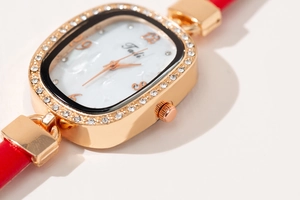 Détail macro du cadran Joli quartz avec lunette en cristal et bracelet en cuir rouge