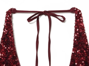 Close-up of wine red sequin dress featuring shimmering texture and satin ribbon ties