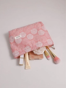 Pink floral embroidered linen makeup bag with zipper showing cosmetic storage capacity