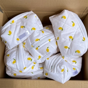Bulk pack of white quilted cotton makeup bags with vibrant yellow lemon patterns