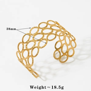 Macro view of 38mm wide gold-plated open cuff bracelet with hollow circle pattern