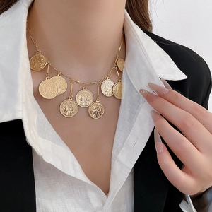 Detail of vintage gold layered coin necklace with portrait embossing on female model