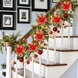 Red and gold poinsettia flowers decorating indoor stairs for Christmas greenery display