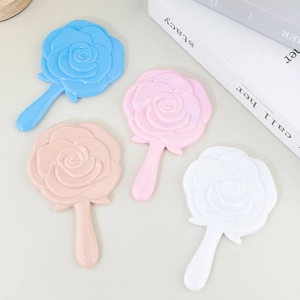 Mini Handspiegel mit Rosenprägung in verschiedenen Pastellfarben auf beigem Hintergrund