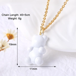 Detail view of a white bear pendant necklace with 45+5cm gold chain length and size specs