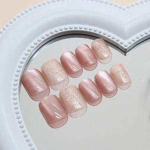 Pink cat eye press-on nails with silver glitter French tips in heart tray