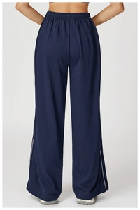 Détail de la taille élastique haute et de la bande latérale sur le pantalon bleu marine
