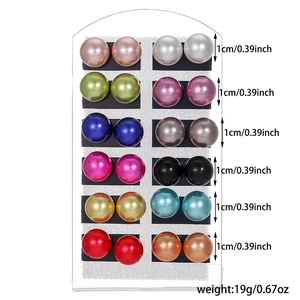 Set of 12 pairs of multi-colored pearl stud earrings displayed on a white stand