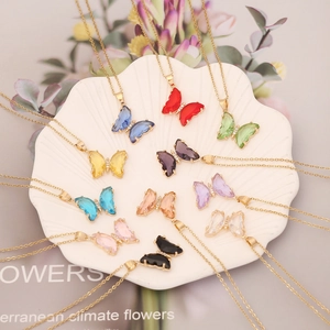 Colliers papillon dorés élégants en 10 couleurs de cristal sur un plateau de vente
