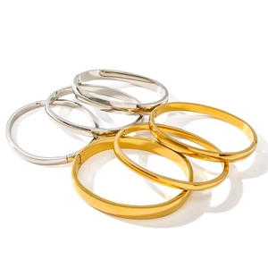 Minimalist stainless steel bangles in gold and silver finish stacked on a white background