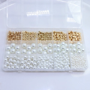 Detail view of a 15-compartment storage box filled with golden beads and white pearls