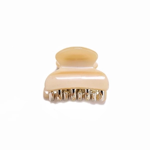 Detailed view of the small beige leopard print hair claw clip with a metal spring mechanism