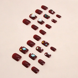 Glossy burgundy press-on nails set with sparkling rhinestones and star charms