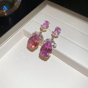 Détail macro de boucles d'oreilles goutte rose avec zircons étincelants et dorure fine
