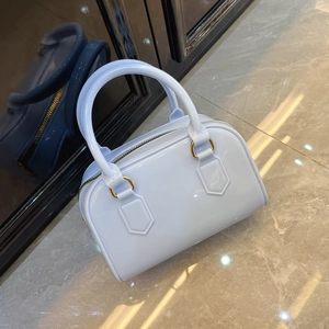 Detailed view of light blue jelly bag featuring smooth texture and gold-toned metal hardware