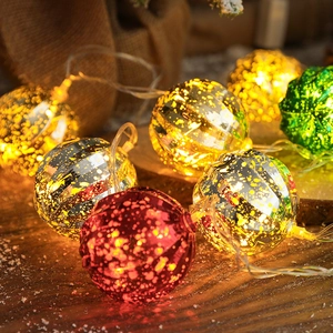 LED Christmas string lights with vintage mercury-style balls on rustic wood tabletop